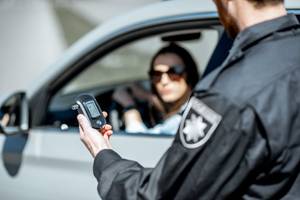 polizei fuehrt bei einer jungen autofahrerin einen alkoholtest durch