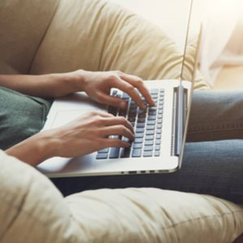 frau mit macbook auf dem schoss