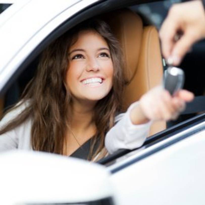 junge frau bekommt schluessel fuer neues auto