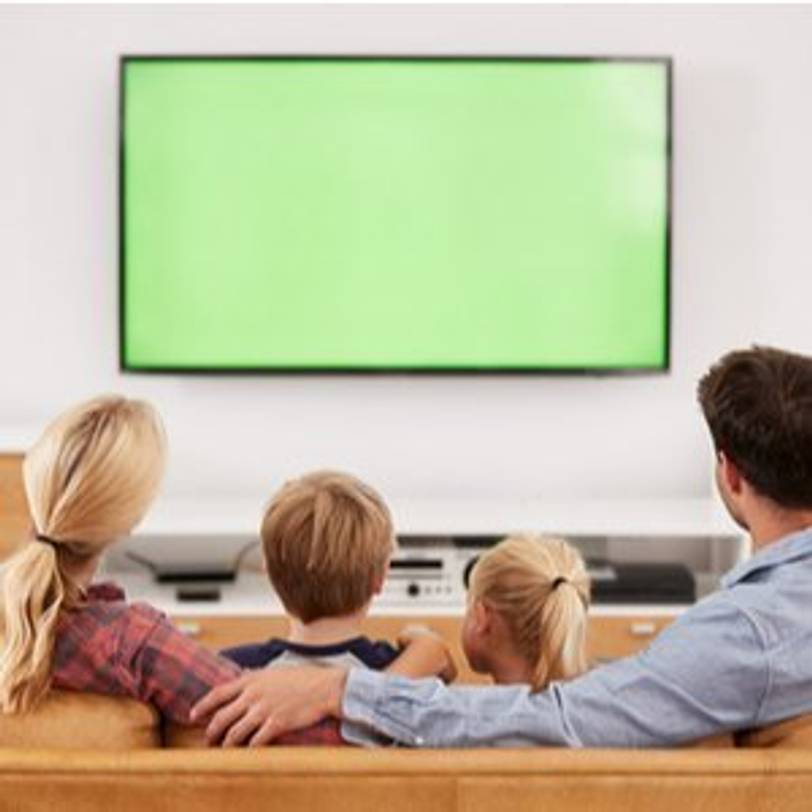 Familie mit zwei Kindern vor Fernseher im Wohnzimmer