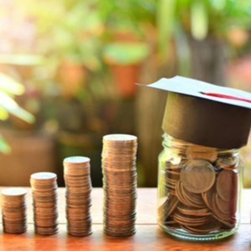 Münzen auf Stapeln und in einem Glas, die Fondssparplan zur Studienfinanzierung des Kindes darstellen sollen