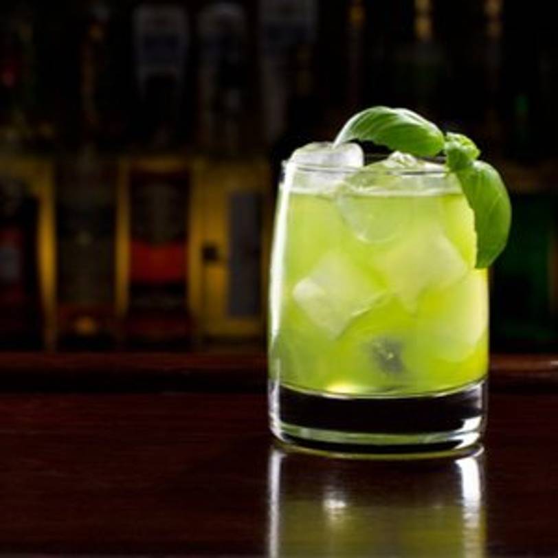 Basil Smash Gin-Cocktail mit Basilikum-Dekoration