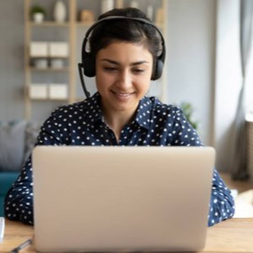 junge frau mit headset an laptop