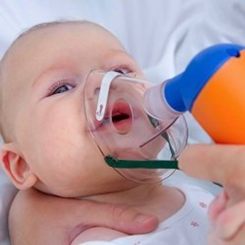 Baby, das über einen Inhalator mit Kochsalzlösung behandelt wird