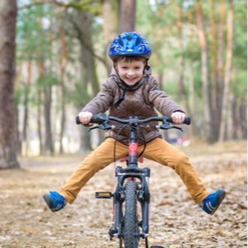 froehlicher junge auf kinderfahrrad