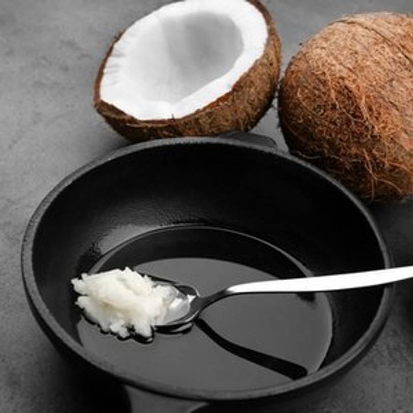 loeffel mit kokosoel in pfanne