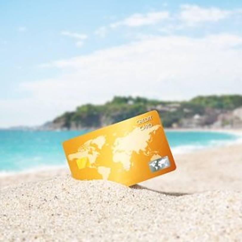 Kreditkarte, die in Sand am Strand steckt
