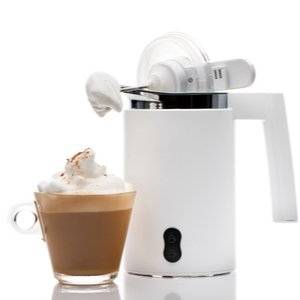 Elektrischer Milchaufschäumer neben einer Tasse Kaffee mit Milchschaum