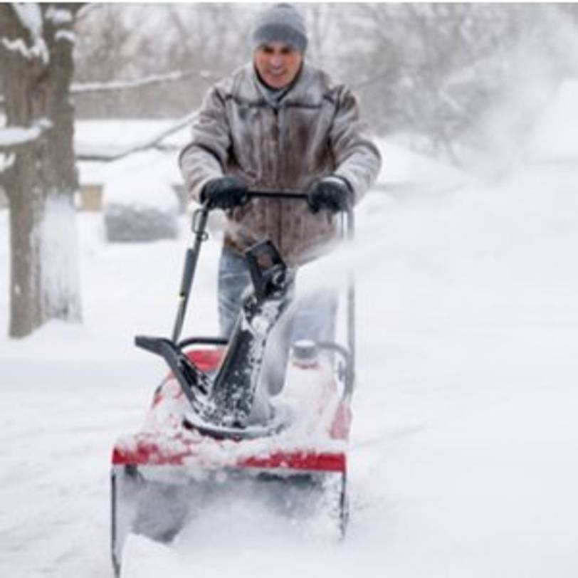 mann arbeitet mit schneefraese