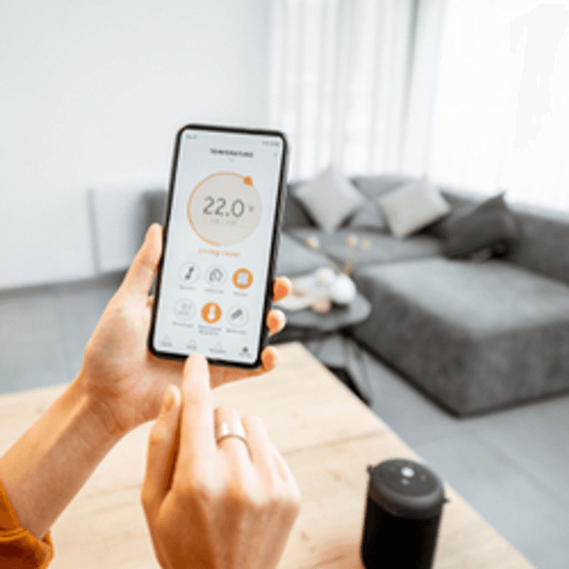 frau bedient smart-home-thermostat ueber handy