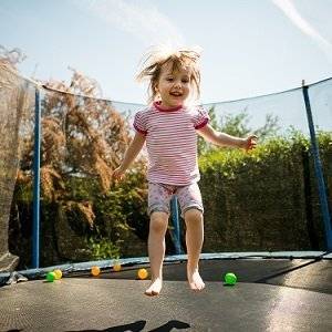 kleines Kind auf Trampolin mit Sicherheitsnetz